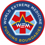The World Extreme Medicine logo with red, white and blue in a circle saying World Extreme Medicine Pushing Boundaries.