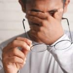Man holding glasses - hypnotherapy training for healthcare professionals