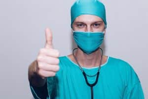 Doctor in mask with thumbs up - hypnotherapy training for healthcare professionals